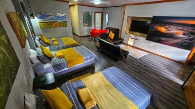 a room with two beds and a flat screen tv at The Elements in Graskop