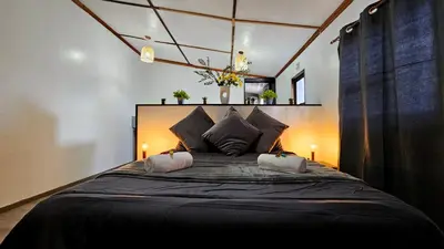 a bedroom with a large black bed with two lamps at The Elements in Graskop