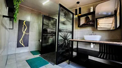 a bathroom with a sink and a shower with a sink at The Elements in Graskop