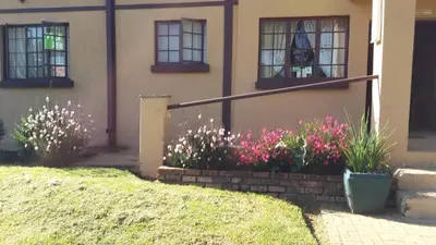 a house with some flowers in front of it at The Old Mill Hotel in Machadodorp