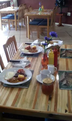 a wooden table with plates of food on it at The Old Mill Hotel in Machadodorp