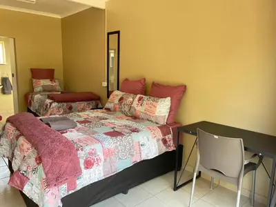 a bedroom with a bed and a desk and a chair at 4 on Sirius in Polokwane