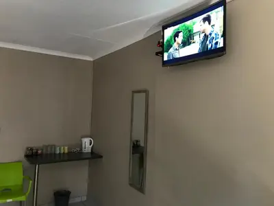 a flat screen tv on the corner of a wall at 4 on Sirius in Polokwane