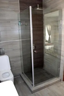 a shower stall in a bathroom with a toilet at Sagwadi Hotel in Hazyview