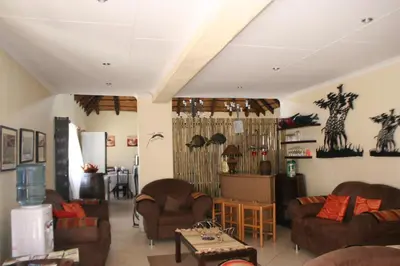 a living room with couches and a table at Villa Royal Palm in Komatipoort