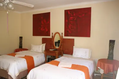 a room with three beds and a mirror at Villa Royal Palm in Komatipoort