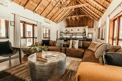 a living room with a couch and a table at Kingly Bush Villa in Phalaborwa