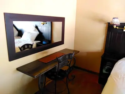 a room with a desk and a mirror on the wall at Zebula Luxury Lodge in Mabula