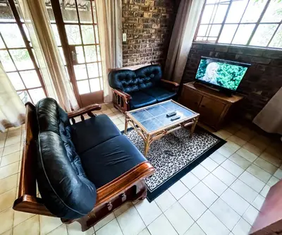 a living room with a leather couch and a coffee table at Masasana’s Rest in Hazyview