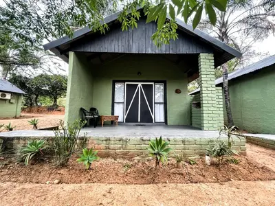 a front porch of a green house with a door at Masasana’s Rest in Hazyview