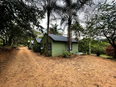 a small green house on the side of a dirt road at Masasana’s Rest in Hazyview