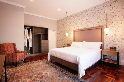 a bedroom with a bed and a desk and a chair at The Rasmus in Pretoria