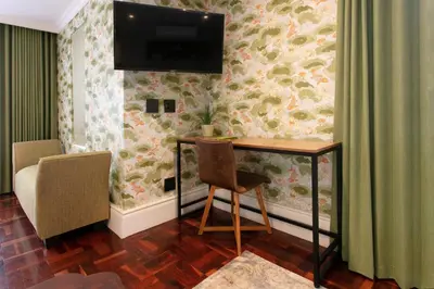 a room with a desk and a television on the wall at The Rasmus in Pretoria