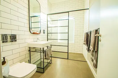 a bathroom with a toilet and a sink and a mirror at The Rasmus in Pretoria