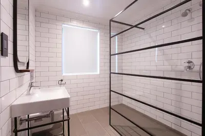 a bathroom with a sink and a glass shower at The Rasmus in Pretoria