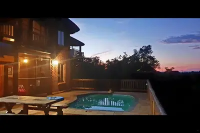 a swimming pool with a picnic table next to a house at Hadeda Lodge, Mabalingwe in Warmbaths