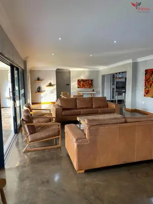 a large living room with brown leather furniture at ANISA GUESTHOUSE in Thohoyandou