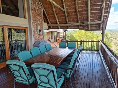 a wooden table and chairs on a deck at Kanaan, Mabalingwe in Mabula