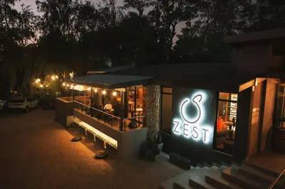 a restaurant with a lit up sign at night at Lowveld Living Guesthouse in Nelspruit