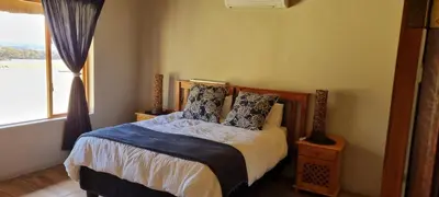 a bedroom with a bed with pillows and a window at Mothopo Game Lodge in Modimolle