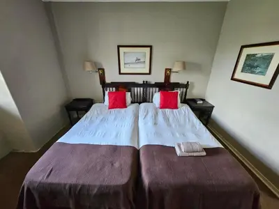 a hotel room with two beds with red pillows at Pietersburg Club in Polokwane