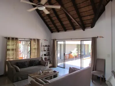 a living room with a couch and a ceiling fan at Swiblati Lodge in Hoedspruit