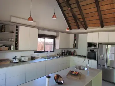 a large kitchen with white cabinets and a sink at Swiblati Lodge in Hoedspruit