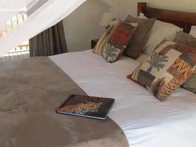 a book sitting on top of a bed at Swiblati Lodge in Hoedspruit