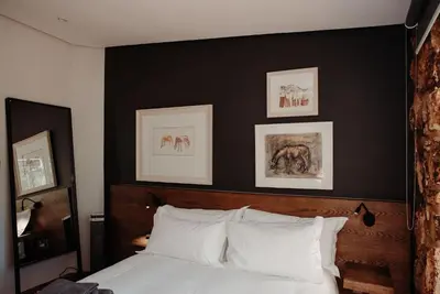 a bedroom with a black wall and a bed with white pillows at Bastion House in Irene