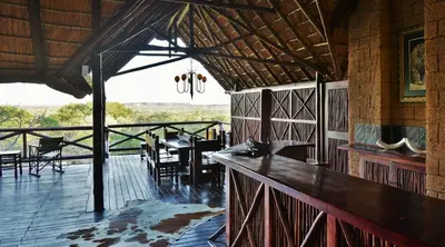 a restaurant with tables and chairs on a wooden deck at Zwahili Private Game Lodge & Spa in Modimolle