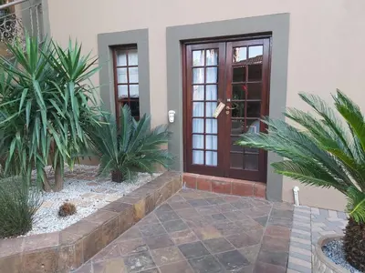 a front door of a house with palm trees at Casabac in Pretoria