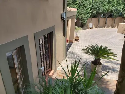 a house with plants in front of a courtyard at Casabac in Pretoria