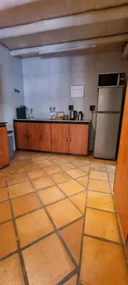a large kitchen with wooden floors and a refrigerator at Casabac in Pretoria