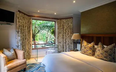 a bedroom with a large bed and a window at Indalo Leaves Lodge and Spa in Nelspruit