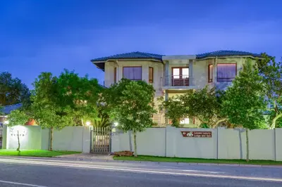 a house with a fence in front of a street at Indalo Leaves Lodge and Spa in Nelspruit
