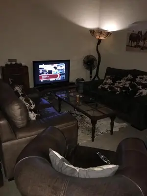 a living room with couches and a flat screen tv at Twenty Four Mabalingwe Nature Reserve in Mabula