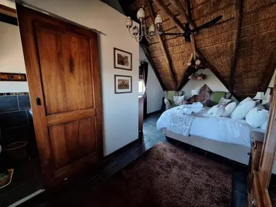 a bedroom with a bed and a wooden door at Twenty Four Mabalingwe Nature Reserve in Mabula