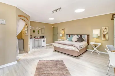 a large bedroom with a bed and a kitchen at Villa Roma - Luxury Accommodation in Centurion
