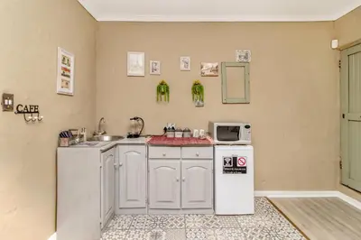 a kitchen with a white refrigerator and a sink at Villa Roma - Luxury Accommodation in Centurion