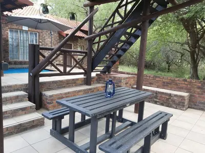 a blue bottle sitting on a picnic table next to a stairs at Peace@Kruger in Marloth Park