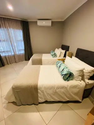 a hotel room with two beds in a room at Letaba Junction Lodge in Letsitele