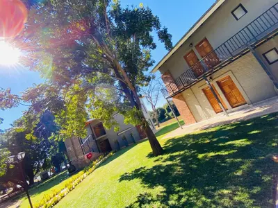 a house with a tree in front of a yard at Letaba Junction Lodge in Letsitele