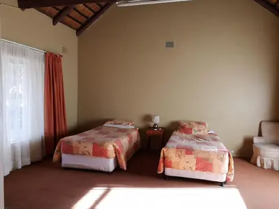 a bedroom with two beds and a window at Aruka in Bela-Bela