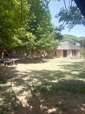 a house with trees in front of a yard at Aruka in Bela-Bela