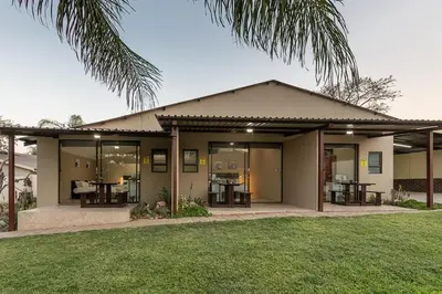a house with glass doors and a palm tree at Kiyala Guest Farm in Nelspruit