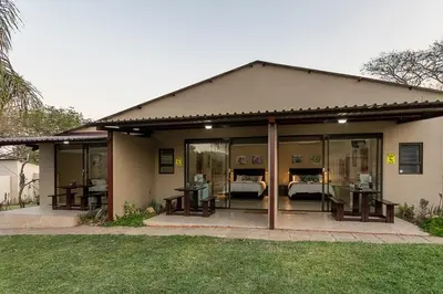 a house with glass doors and tables in a yard at Kiyala Guest Farm in Nelspruit