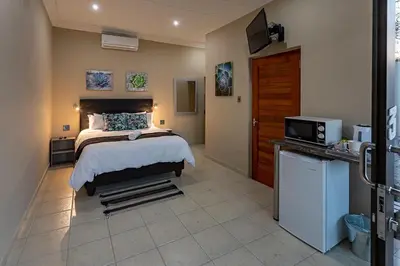 a bedroom with a bed and a tv in a room at Kiyala Guest Farm in Nelspruit