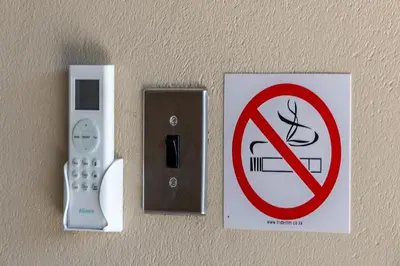 a no smoking sign and a remote control on a wall at Kiyala Guest Farm in Nelspruit
