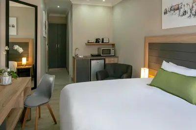 a hotel room with a bed and a desk at Hotel AT Hatfield Apartments in Pretoria