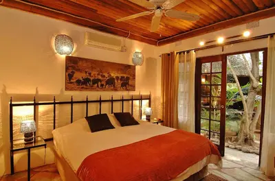 a bedroom with a bed and a ceiling fan at Kaia Tani Exclusive Guesthouse in Phalaborwa